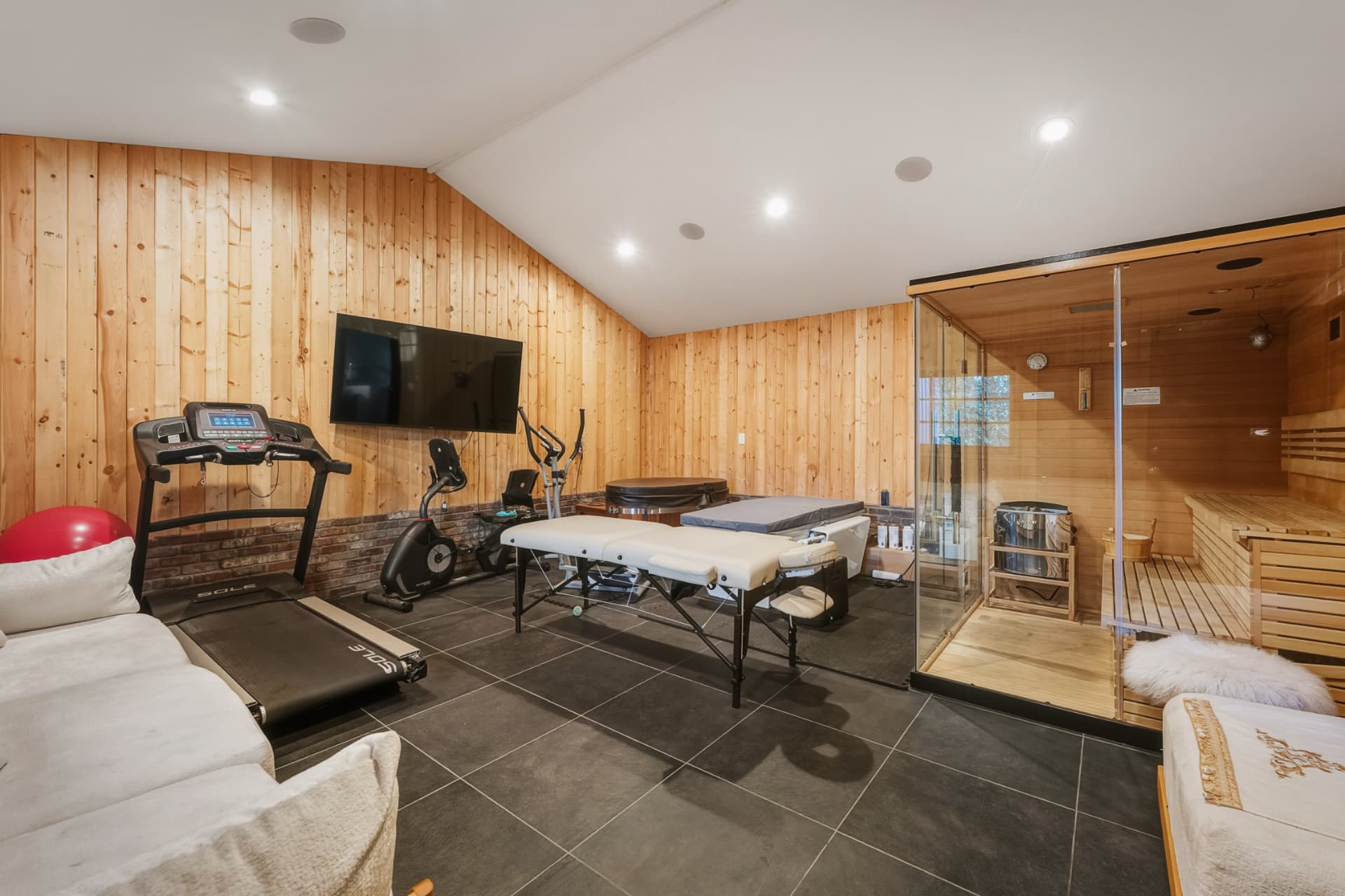 Recovery room with sauna, treadmill, bike, and treatment table