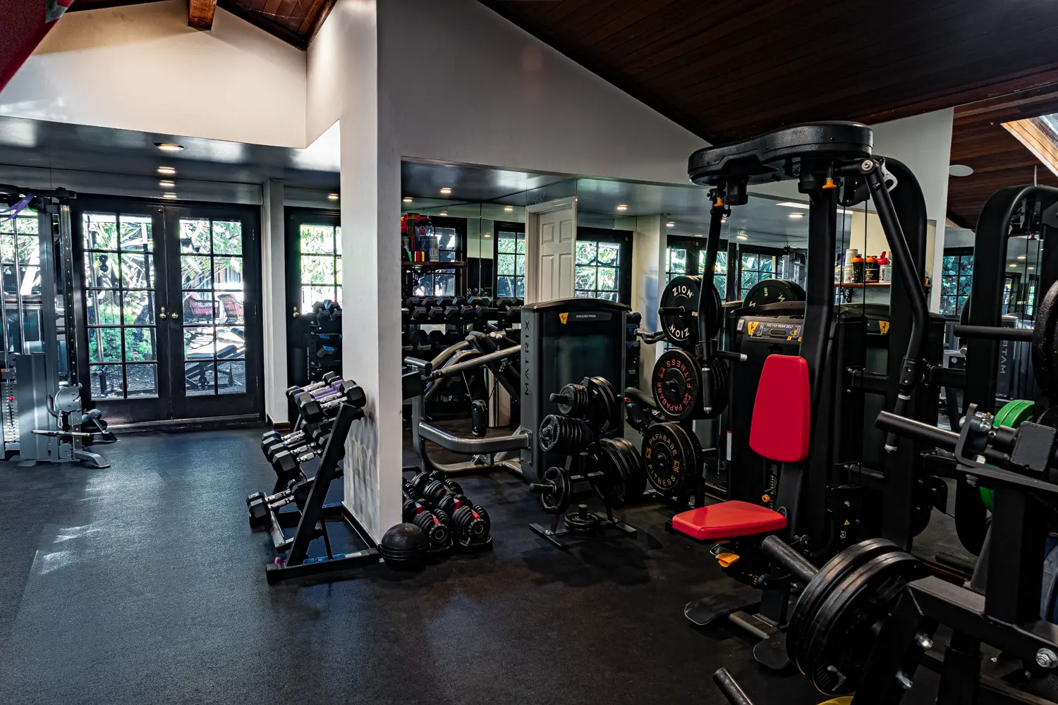 Everlast bag and plate-loaded machines mirrored across the room